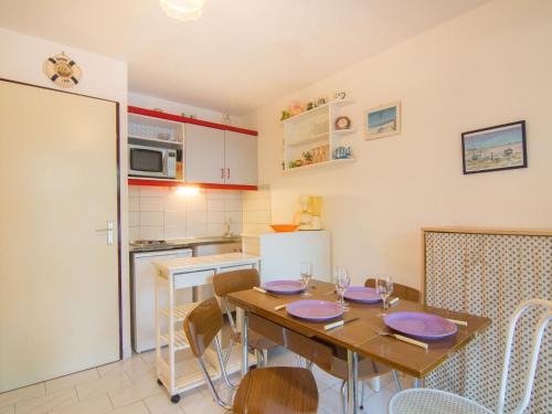 une cuisine avec une table en bois et une salle à manger dans l'établissement Studio Les Cyprianes-6 by Interhome, à La Grande Motte