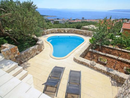 una piscina con 2 tumbonas junto a ella en Holiday Home Belvedere by Interhome, en Veliko Brdo