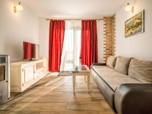 sala de estar con sofá y cortinas rojas en Holiday Home Belvedere by Interhome, en Veliko Brdo