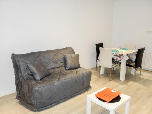a living room with a couch and a table at Apartment Saint Thomas by Interhome in Saint Malo