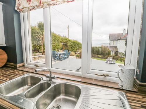 a kitchen with a sink and a large window at Bryn y Don in Benllech