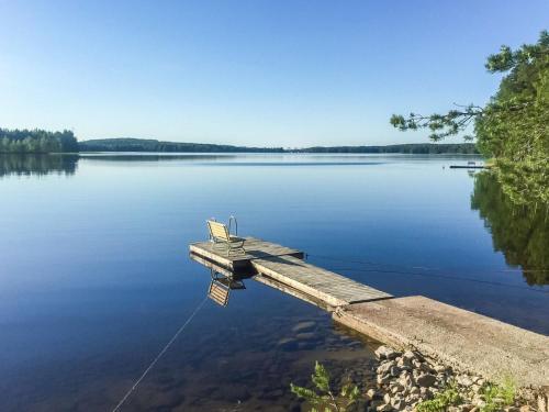 a dock on a lake with a bench on it at Holiday Home Kettukallio by Interhome in Luhtanen