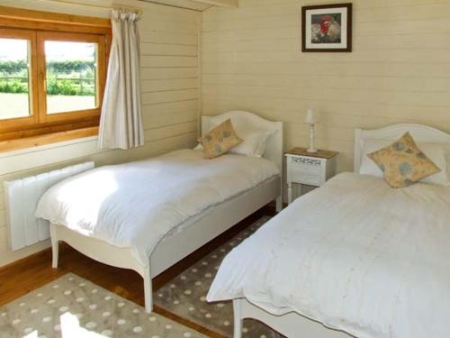 a bedroom with two beds and a window at Cropvale Lodge in Charlton
