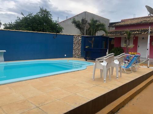 a patio with chairs and a swimming pool at Suites piscina Búzios in Búzios