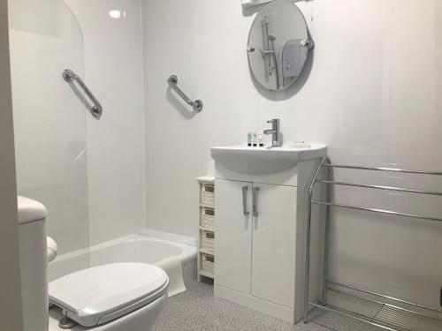 a bathroom with a sink and a toilet and a mirror at Great Western Hotel Guest House in Paignton