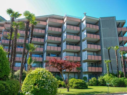 an apartment building with palm trees and bushes at Apartment App- 511 by Interhome in Bissone