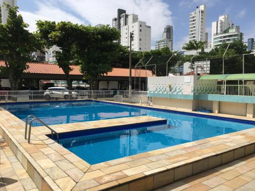 a large swimming pool in a city with tall buildings at Studio à 500m da praia, AC e Vaga in Balneário Camboriú