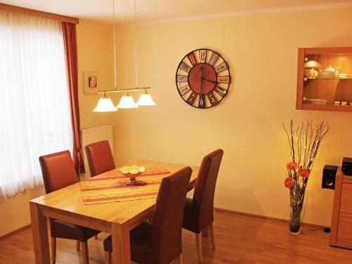 einen Esstisch mit Stühlen und eine Uhr an der Wand in der Unterkunft Apartment Bibelöd-6 by Interhome in Ruhpolding