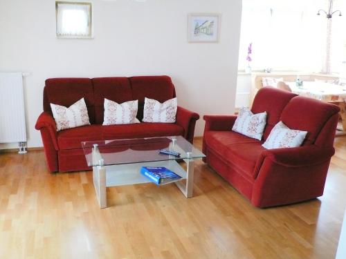 un soggiorno con divano rosso e tavolino da caffè di Apartment Bibelöd-7 by Interhome a Ruhpolding