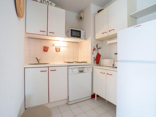 ラ・グランド・モットにあるApartment Aurore-3 by Interhomeの白いキッチン(白いキャビネット、電子レンジ付)