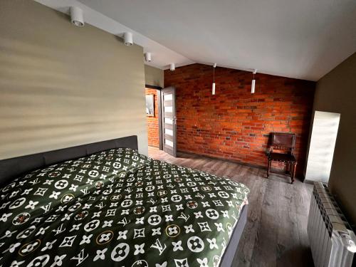 una camera con letto e muro di mattoni di Apartamenty na 1 Maja a Skierniewice