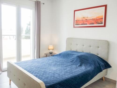une chambre avec un lit avec une couverture bleue dans l'établissement Apartment Terrasse de Lucie by Interhome, à Saint-Cyprien