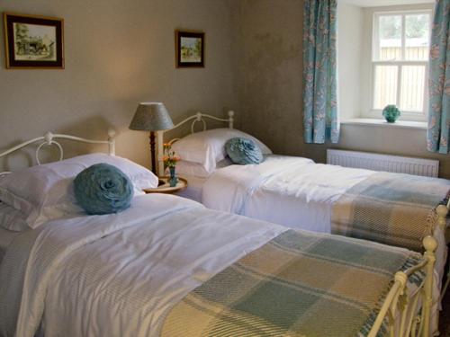 a bedroom with two beds and a window at Town Head Farm in Malham