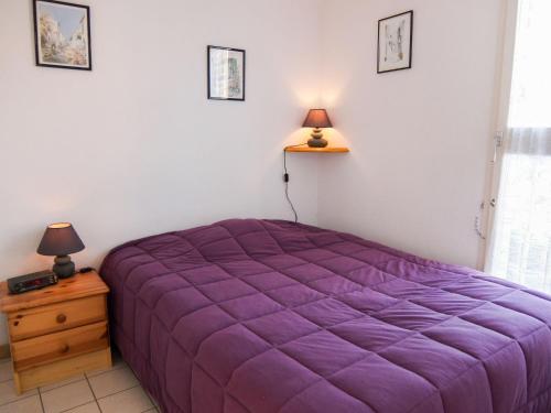 - une chambre avec un lit violet, une table de chevet et des lampes dans l'établissement Apartment Marina Village-5 by Interhome, à Saint Cyprien Plage