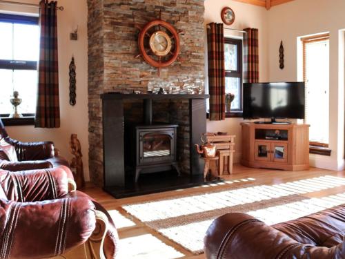 a living room with a fireplace and a television at Holiday Home Glenn Cottage by Interhome in Uig