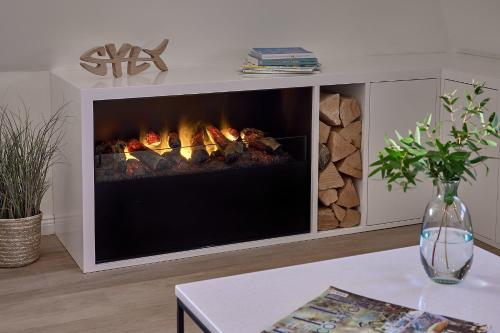a fireplace in a living room with a table at KEITUM unique POOL I VIEW I GARDEN in Keitum