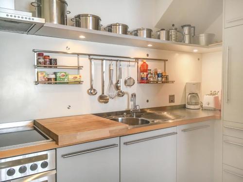 una cucina con armadi bianchi, lavandino e utensili di Apartment Jungfrau a d Ledi-1 by Interhome a Wengen