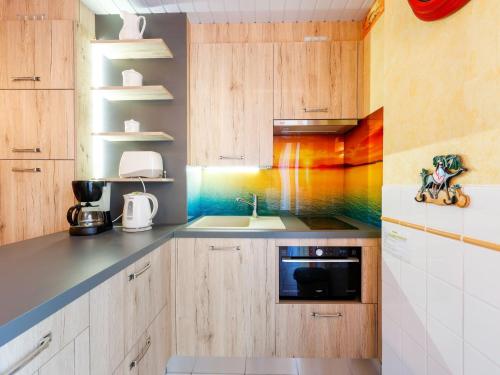 une cuisine avec un tableau arc-en-ciel sur le mur dans l'établissement Apartment Le Génois by Interhome, au Cap d'Agde
