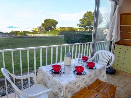 - une table et des chaises sur une terrasse couverte offrant une vue sur un champ dans l'établissement Apartment Le Grand Large by Interhome, à Six-Fours-les-Plages