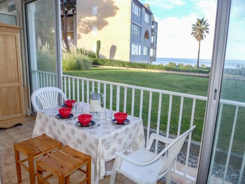 d'une table et de chaises sur un balcon avec vue sur l'océan. dans l'établissement Apartment Le Grand Large by Interhome, à Six-Fours-les-Plages