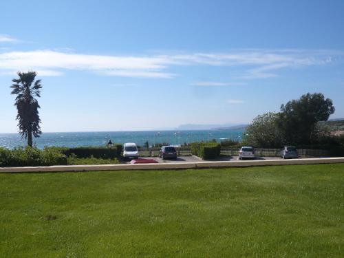 - un parking avec des voitures garées à côté de l'océan dans l'établissement Apartment Le Grand Large by Interhome, à Six-Fours-les-Plages