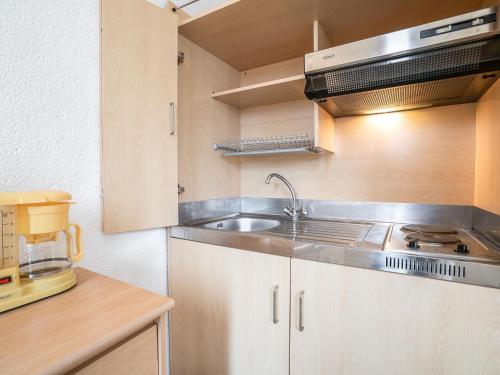 une petite cuisine avec un évier et un micro-ondes dans l'établissement Studio Les Amandiers by Interhome, à Canet
