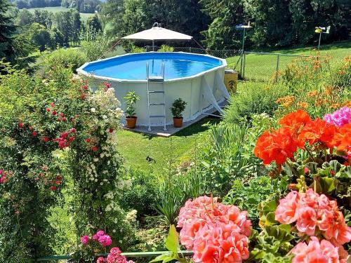 a garden with a hot tub in the middle of flowers at Apartment Ferienwohnungen Magdalensberg by Interhome in Gröblach
