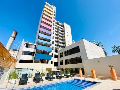 a swimming pool in front of a tall building at Gran Cavancha Suite in Iquique