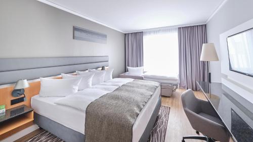 a hotel room with a bed and a tv at Holiday Inn Berlin Airport - Conference Centre by IHG in Schönefeld