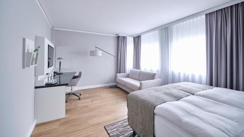 a bedroom with a bed and a desk and a chair at Holiday Inn Berlin Airport - Conference Centre by IHG in Schönefeld