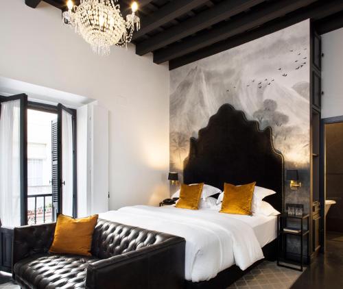 um quarto com uma cama grande e um sofá em Boutique Hotel Casa Cánovas em Cádiz