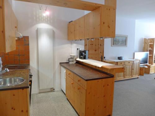 una grande cucina con armadi in legno e lavandino di Apartment Chesa Cromer by Interhome a Celerina