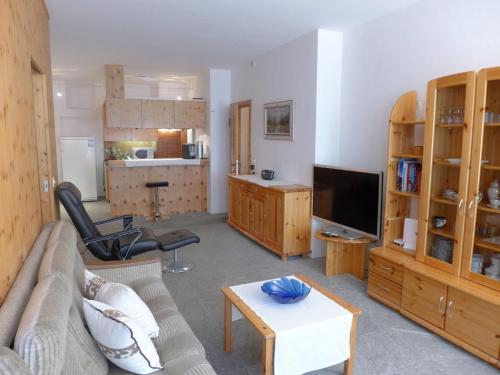- un salon avec un canapé et une télévision dans l'établissement Apartment Chesa Cromer by Interhome, à Celerina