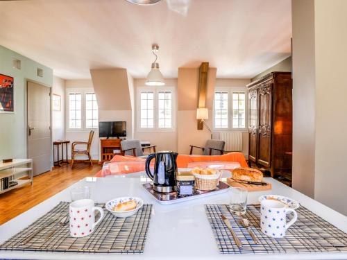 een keuken en een woonkamer met een tafel met eten erop bij Apartment Grands Degrès by Interhome in Saint-Malo