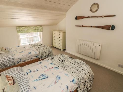 een slaapkamer met 2 bedden en een honkbalknuppel aan de muur bij Clevelyn in Staithes