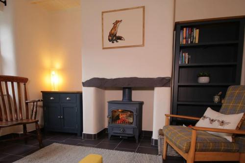 ein Wohnzimmer mit einem Holzofen im Zimmer in der Unterkunft Riverside cottage walking distance into Caernarfon in Caernarfon