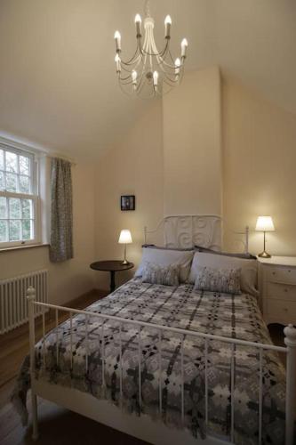 a bedroom with a bed and a chandelier at Riverside cottage walking distance into Caernarfon in Caernarfon