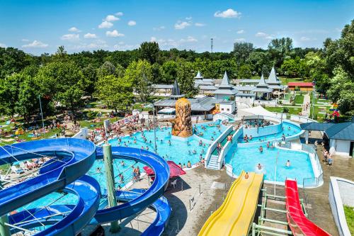 a large water park with people swimming and slides at Svájci Lak Panzió in Nyíregyháza