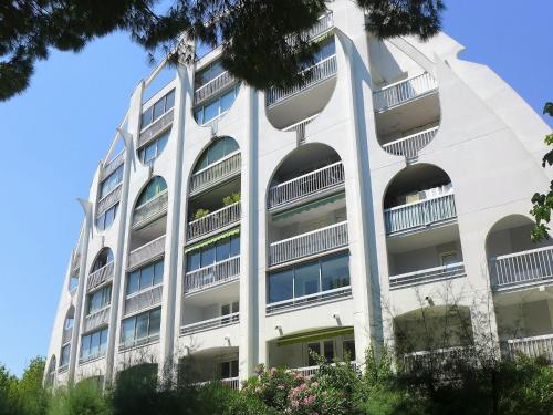 - un bâtiment blanc avec des balcons et des arbres dans l'établissement Apartment Bali by Interhome, à La Grande Motte