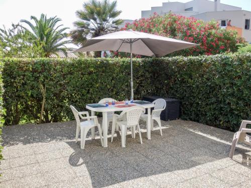 une table et des chaises avec un parasol sur une terrasse dans l'établissement Apartment Les Frégates-13 by Interhome, à Saint Cyprien Plage