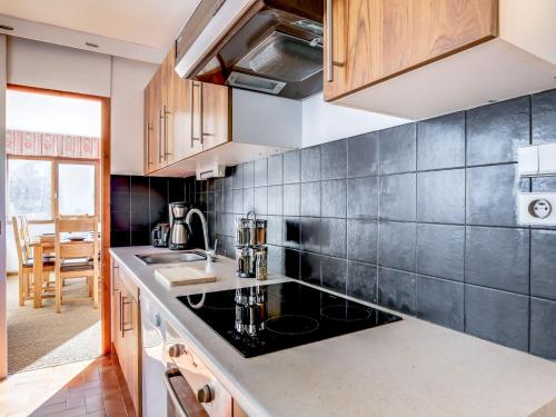 a kitchen with a black counter top and wooden cabinets at Apartment Fleurs des Alpes-1 by Interhome in Saint-Gervais-les-Bains