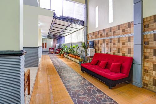 czerwona kanapa na środku korytarza w obiekcie Super OYO 90642 Lancar Homestay Syariah w mieście Tlekung