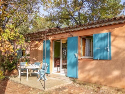 une petite maison avec des portes bleues, une table et des chaises dans l'établissement Holiday Home La Colline des Ocres by Interhome, à Villars