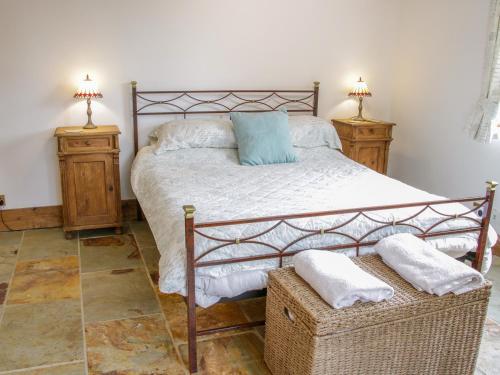 a bedroom with a large bed with two night stands at Gardeners Cottage in Nantwich