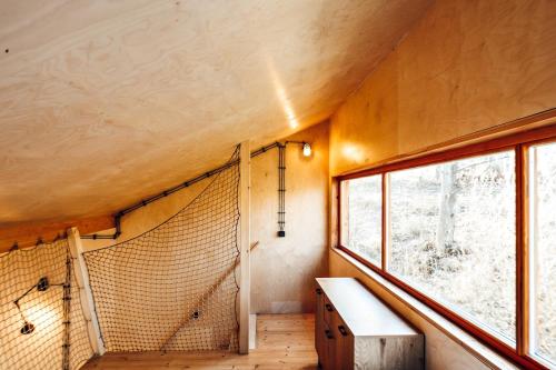 a room with a window and a net at Tři domky - tiny houses in Děpoltice
