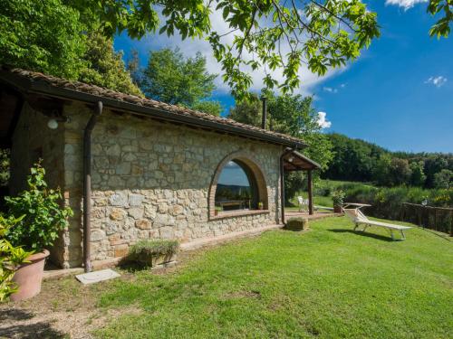 a stone building with a bench in a yard at Holiday Home Casale Belvedere by Interhome in Roccastrada