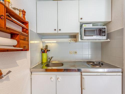 une cuisine avec un évier et un micro-ondes dans l'établissement Studio La Borgia A- B- C-11 by Interhome, aux Contamines-Montjoie