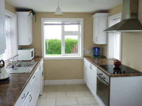 a kitchen with a sink and a window in it at Ocean View in Ballinskelligs