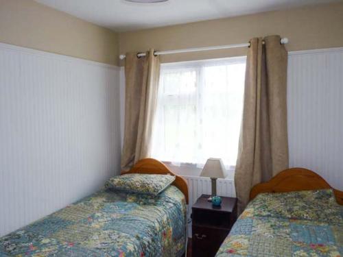 1 dormitorio con 2 camas y ventana en Ocean View, en Ballinskelligs