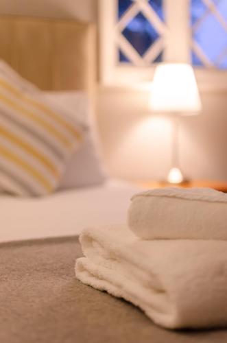 a pile of towels on a table next to a lamp at The Alverbank Hotel in Gosport